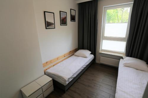 a small room with a bed and a window at Apartamenty MGM Legionowo in Legionowo