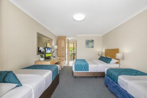 a hotel room with two beds and a television at Best Western Airport 85 Motel in Brisbane