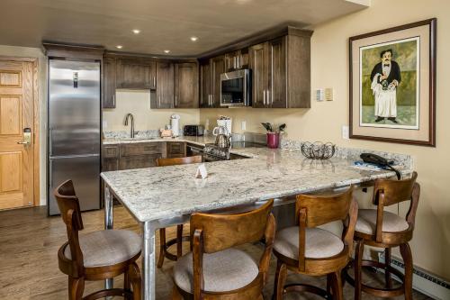 a kitchen with a marble counter top and wooden cabinets at Ptarmigan House in Steamboat Springs