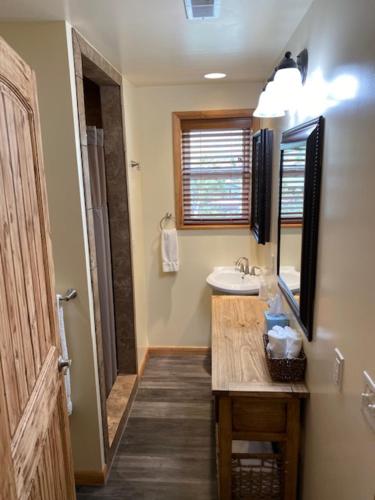 een badkamer met een wastafel en een spiegel bij Yellowstone Riverside Cottages in Gardiner