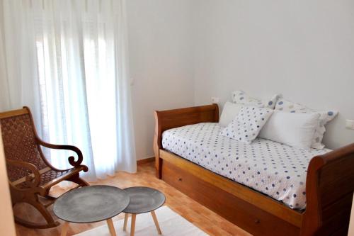 a bedroom with a bed and a table and a chair at Casa Padín in Sanxenxo