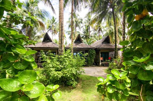 una casa con delle palme davanti di Ferra Resort Siargao a General Luna