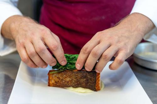 a person is making a sandwich on a plate at Best Western Plus Hotel Monza e Brianza Palace in Cinisello Balsamo