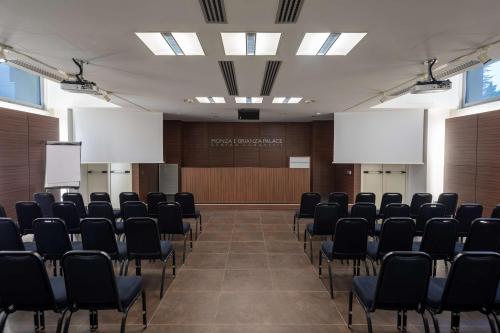 a room with rows of chairs and a podium at Best Western Plus Hotel Monza e Brianza Palace in Cinisello Balsamo