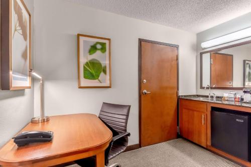 a room with a desk with a computer and a chair at Hyatt Place Charlotte Airport Billy Graham Parkway in Charlotte