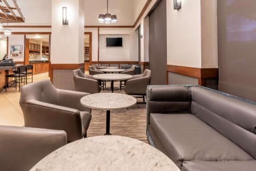a waiting room with couches and tables at Hyatt Place Charlotte Airport Billy Graham Parkway in Charlotte