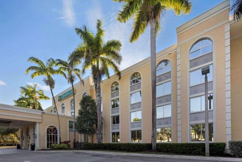 an office building with palm trees in front of it at La Quinta Inn & Suites by Wyndham Sunrise in Sunrise