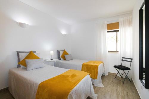 a white room with two beds and a window at Sunny Home Oura By ALzira in Albufeira