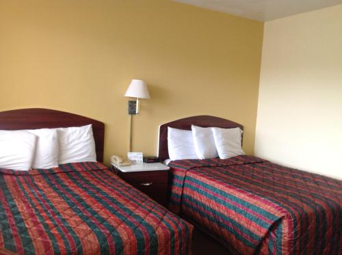 a hotel room with two beds and a telephone at Economy Inn Okeechobee in Okeechobee