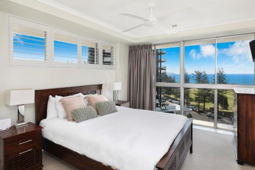 een slaapkamer met een groot bed en een groot raam bij Points North Apartments in Gold Coast