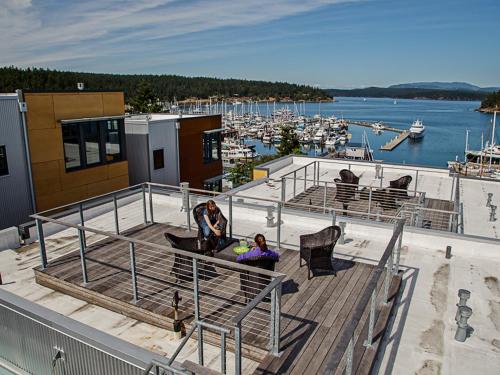 two people sitting on a deck overlooking a marina at Island Inn at 123 West in Friday Harbor