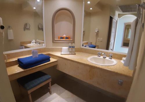 een badkamer met een wastafel en een grote spiegel bij El Cozumeleño Beach Resort - All Inclusive in Cozumel
