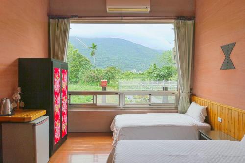 a room with two beds and a large window at Ying Tian Ye Homestay in Jian