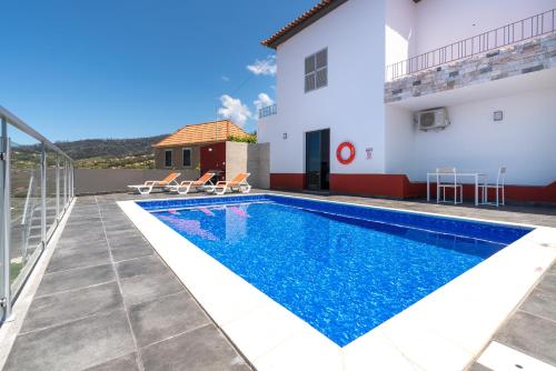 a villa with a swimming pool and a house at Roraima House - Private Pool & Garden in Calheta