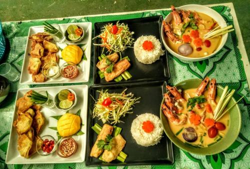 um grupo de pratos de alimentos sobre uma mesa em Nan Inn Bungalow em Praia de Karon