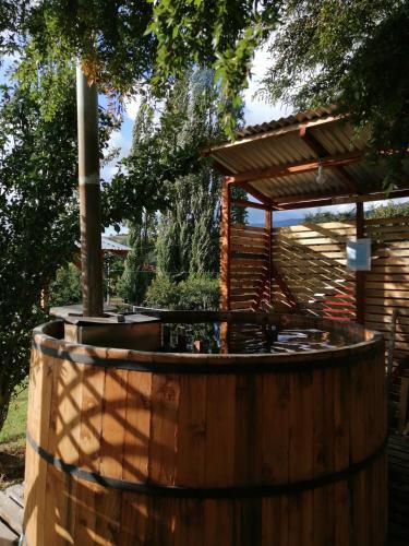 a wooden barrel with a gazebo in a garden at Turismo Jaos Cabañas Tinas y Quincho in Futrono