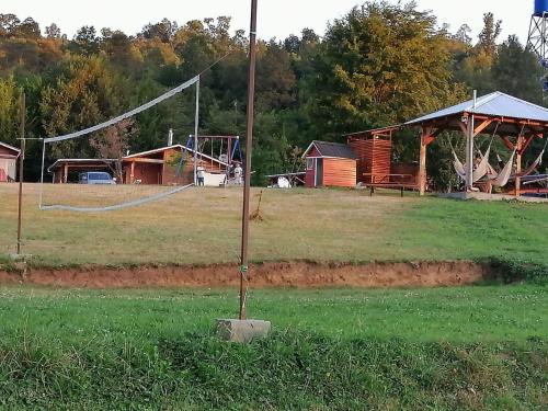 a pole in the middle of a field with a playground at Turismo Jaos Cabañas Tinas y Quincho in Futrono