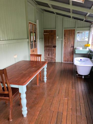 a dining room with a table and a bath tub at Dayboro - Blue Ridge Lavender Cottage in Dayboro