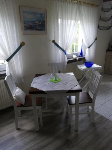 a dining room table with white chairs and a table and a table and chairsktop at Ferienwohnung Hertha in Wernigerode