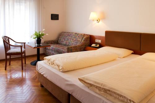 a hotel room with a bed and a couch at Hotel Adria in Bolzano