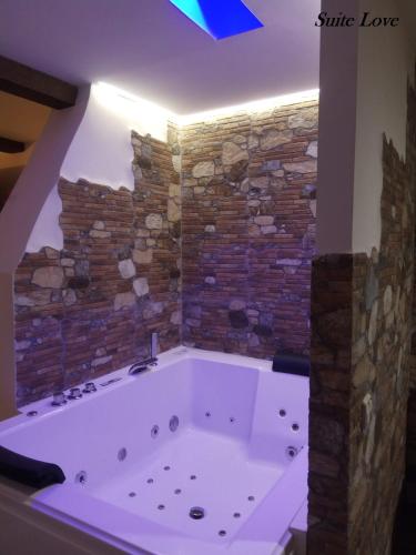 a large bath tub in a room with a brick wall at Suite Love Jacuzzi (Casas Toya) in Uceda