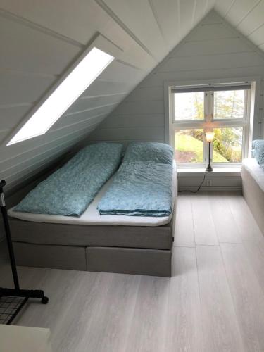 a bed in a attic room with a window at Tunold Gård - Freden in Stryn