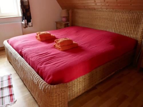 a bed with red sheets and two pillows on it at Öko-Ferienwohnung-Kiel Lachmöwe in Kiel