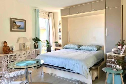 une chambre avec un grand lit et une table dans l'établissement ANTINEA, à Cassis