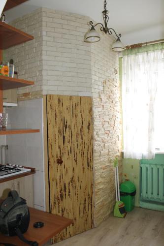 a wooden door in a kitchen with a brick wall at Исторический центр in Chernihiv