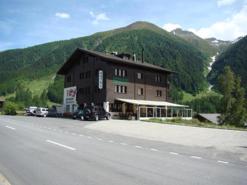 ein großes braunes Gebäude an der Seite einer Straße in der Unterkunft Hotel Weisshorn in Ritzingen