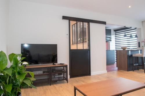 a living room with a tv and a table at Cocoon in East-Brussels in Wezembeek-Oppem