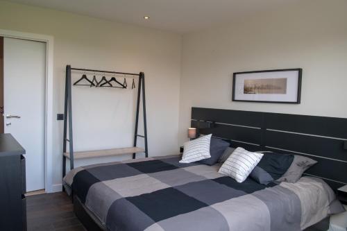 een slaapkamer met een groot bed en een zwart-witte deken bij Cocoon in East-Brussels in Wezembeek-Oppem