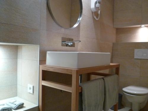 bagno con lavandino, servizi igienici e specchio di Hotel Rossetti a Nizza