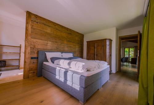 a bedroom with a large bed with a wooden wall at Alpenchalet Kogel in Bad Tölz