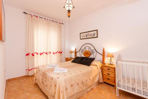una camera con letto e culla di Cañada del Barco Holiday Apartment a Torrox
