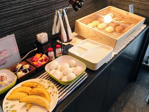 a buffet with bread eggs and other foods on a counter at SAKURA SKY HOTEL KASHIWA(桜スカイホテル柏) in Kashiwa