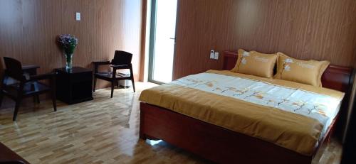 een slaapkamer met een bed en een tafel en stoelen bij Bana Home & Spa in Hội An