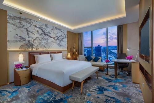 a hotel room with a bed and a large window at Holiday Inn Express Zhengzhou Longzi Lake by IHG in Yaoqiao