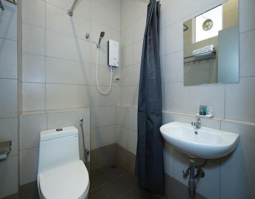 a bathroom with a toilet and a sink at Aurora Boutique Hotel in Bahau