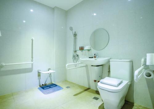 a bathroom with a toilet and a sink and a mirror at The Marison Hotel in Legazpi