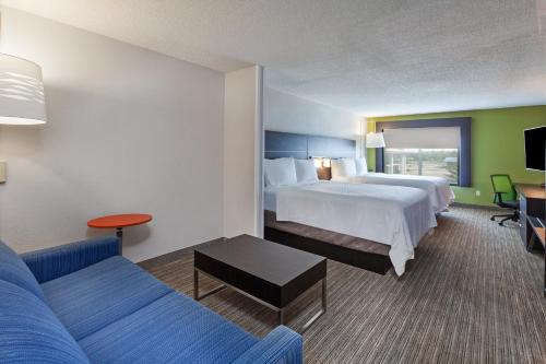 a hotel room with two beds and a couch at Holiday Inn Express New Orleans East by IHG in New Orleans