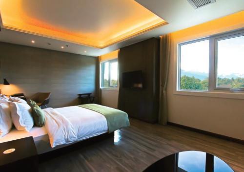 a bedroom with a bed and a large window at The Marison Hotel in Legazpi