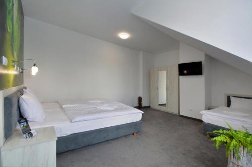 a bedroom with a bed and a staircase at Hotel Roztocze in Zwierzyniec