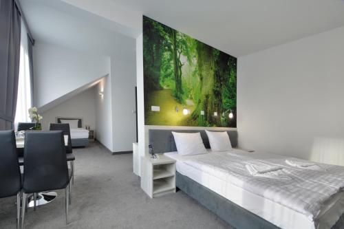 a bedroom with a bed and a painting on the wall at Hotel Roztocze in Zwierzyniec