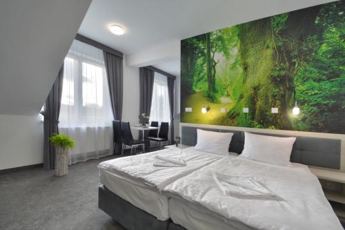 a bedroom with a bed and a large painting on the wall at Hotel Roztocze in Zwierzyniec