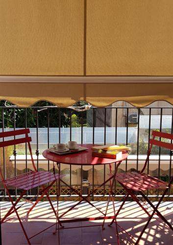 a table with two chairs and a table with plates on it at La Foresteria Garden Boutique B&B in Catania