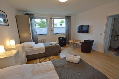 ein Hotelzimmer mit 2 Betten und einem TV in der Unterkunft Appartement Wildkamp in Salzgitter