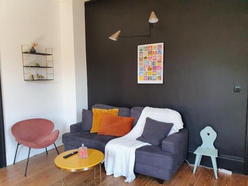 a living room with a blue couch and a table at Sojolidays - Appartements d'hôtes sur la Route des Vins d'Alsace in Rorschwihr