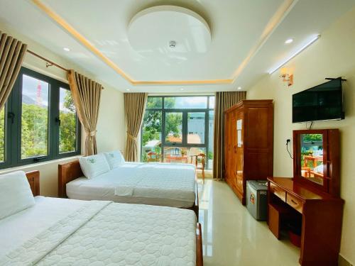 1 dormitorio con 2 camas y TV de pantalla plana en Khách sạn Phúc Lộc An Côn Đảo, en Con Dao
