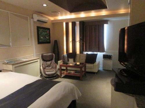 a hotel room with a bed and a tv at ウォーターゲート鹿児島 in Kagoshima